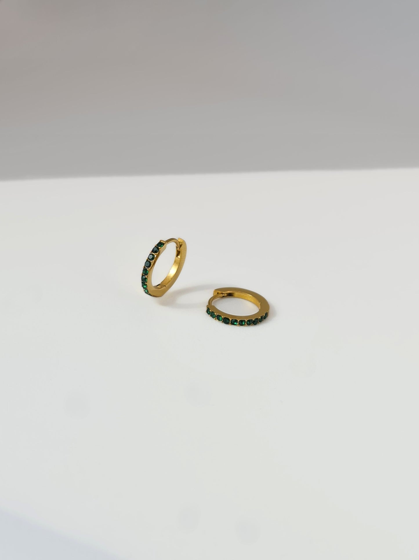 The Maija 'May' Emerald Birthstone 18k Gold Plated Stainless Steel Crystal Huggie Hoop Earrings.