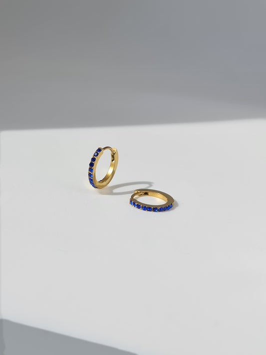 The Maija 'September' Sapphire Birthstone 18k Gold Plated Stainless Steel Crystal Huggie Hoop Earrings.