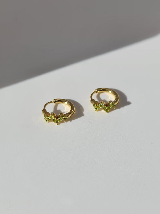 The Lumen 18k Gold Plated Stainless Steel Clustered Crystal Huggie Hoop Earrings in Peridot Green Cubic Zirconia.
