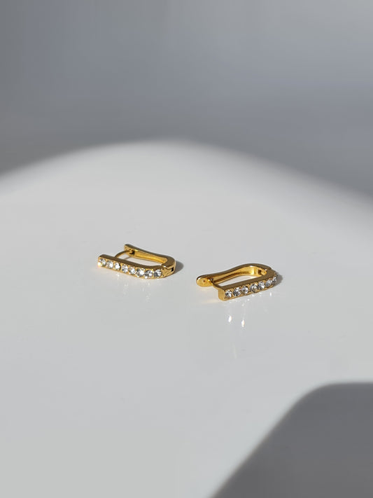 The Bobbie 18k Gold Plated Stainless Steel Cubic Zirconia Pave Crystal Oval Huggie Hoop Earrings.