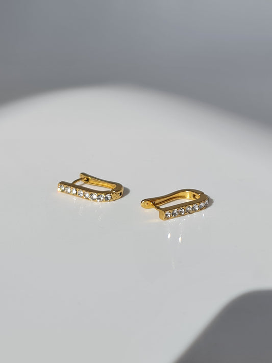 The Bobbie 18k Gold Plated Stainless Steel Cubic Zirconia Pave Crystal Oval Huggie Hoop Earrings.