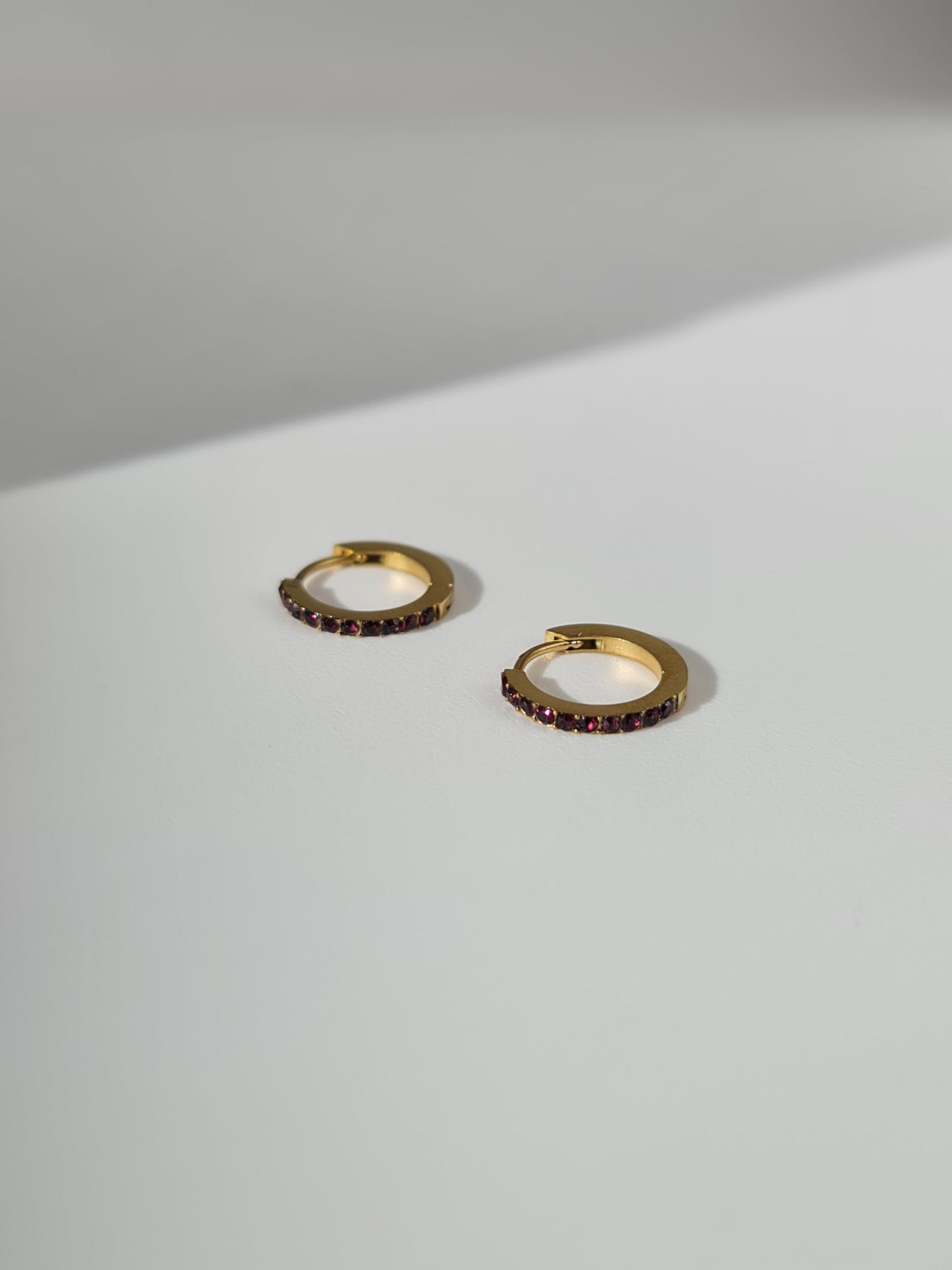 The Maija 'July' Ruby Birthstone 18k Gold Plated Stainless Steel Crystal Huggie Hoop Earrings.