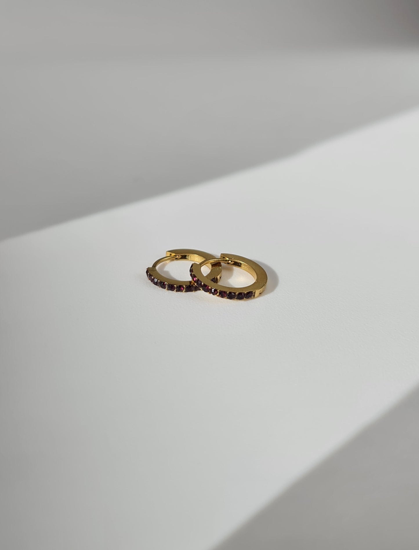 The Maija 'July' Ruby Birthstone 18k Gold Plated Stainless Steel Crystal Huggie Hoop Earrings.