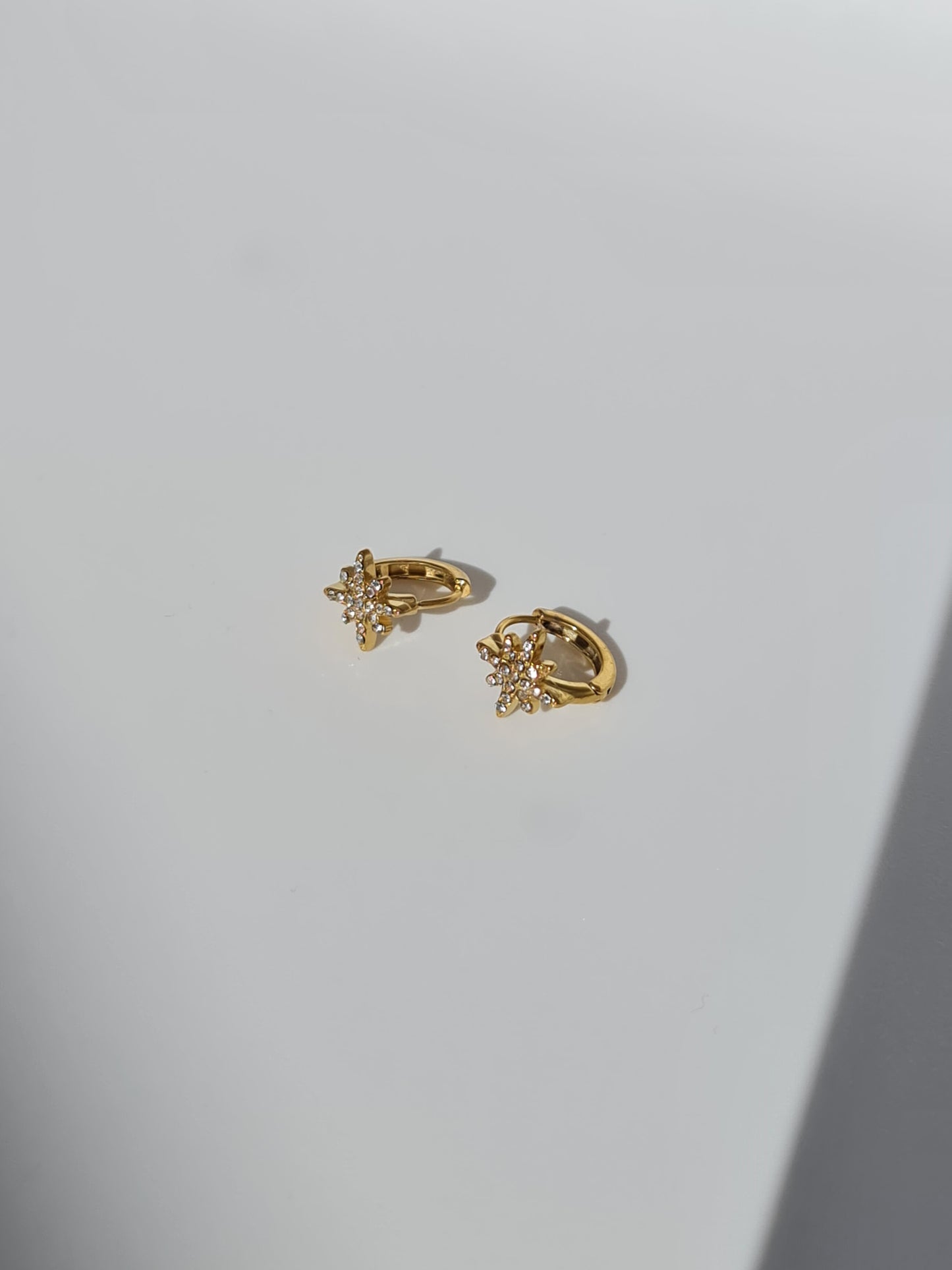 The Astra 18k Gold Plated Stainless Steel Cubic Zirconia Pave Crystal Celestial Star Huggie Hoop Earrings.
