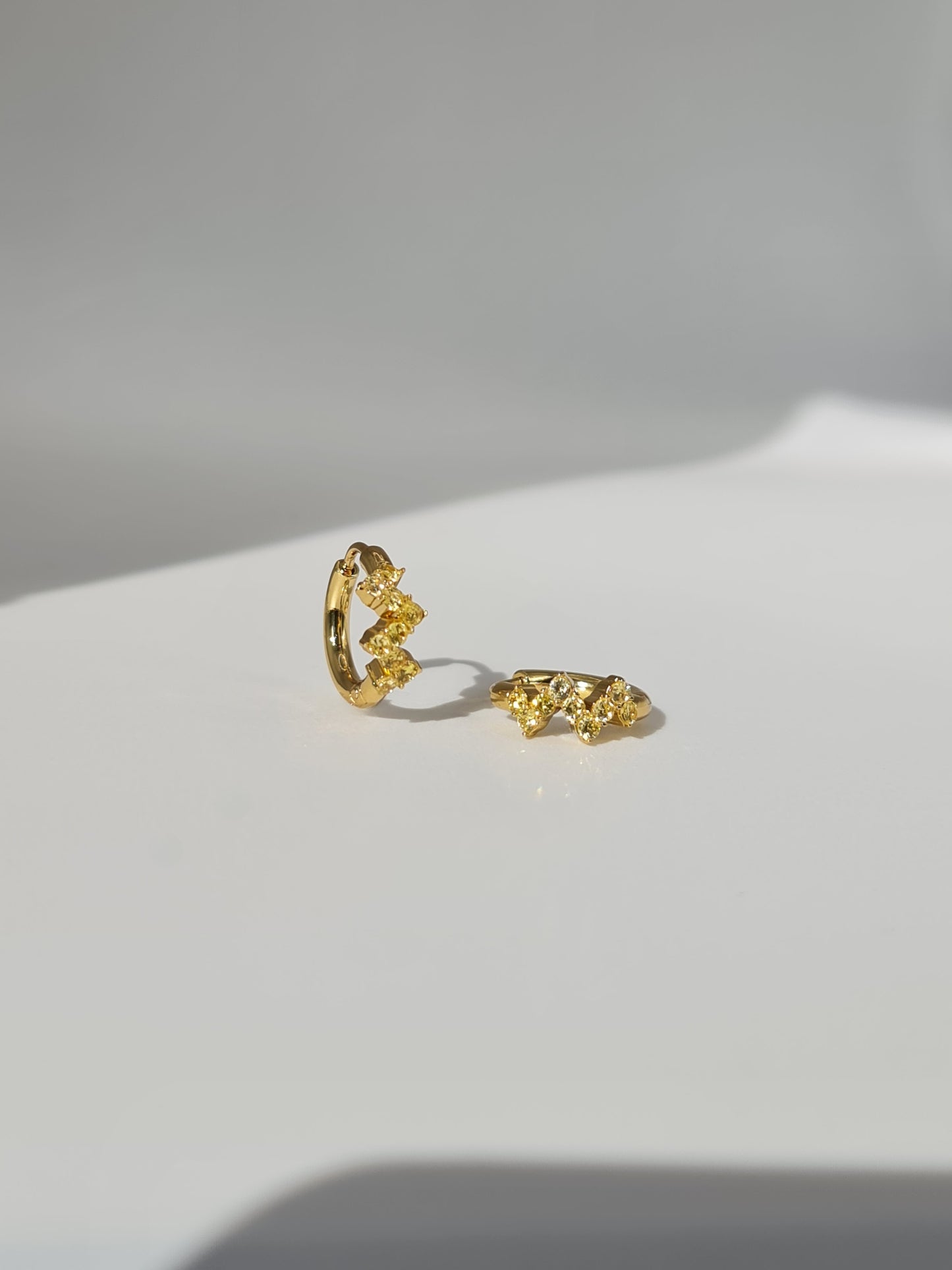 The Lumen 18k Gold Plated Stainless Steel Clustered Crystal Huggie Hoop Earrings in Citrine Yellow Cubic Zirconia.