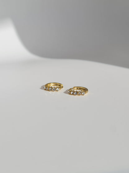 The Cameron 18k Gold Plated Stainless Steel Cubic Zirconia Crystal Huggie Hoop Earrings.