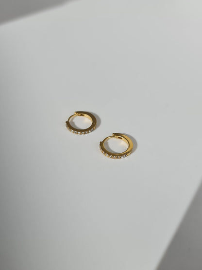 The Maija 'April' Diamond CZ Birthstone 18k Gold Plated Stainless Steel Crystal Huggie Hoop Earrings.