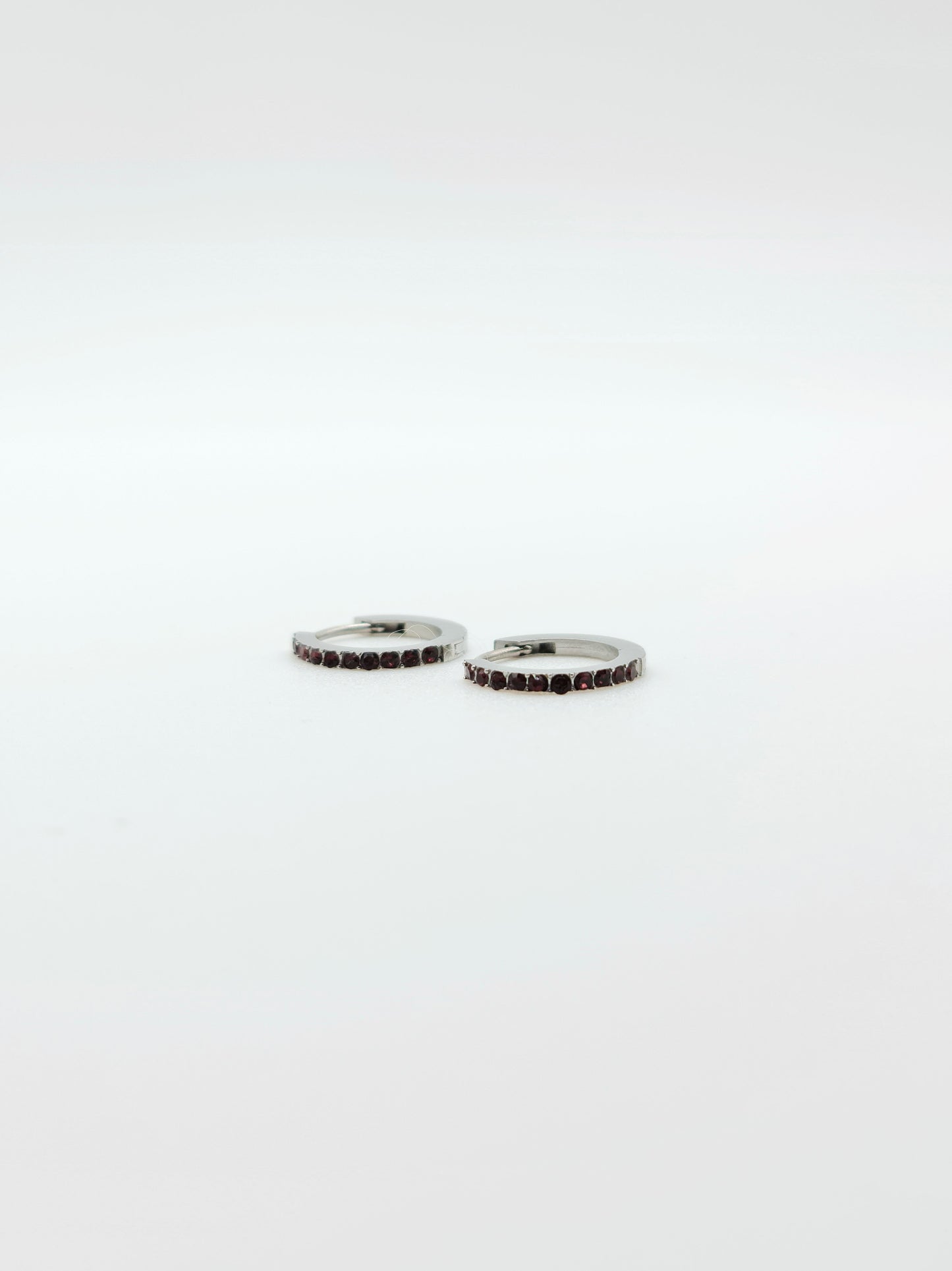 The Maija 'July' Ruby Birthstone Silver Finish Tarnish Free Crystal Huggie Hoop Earrings.