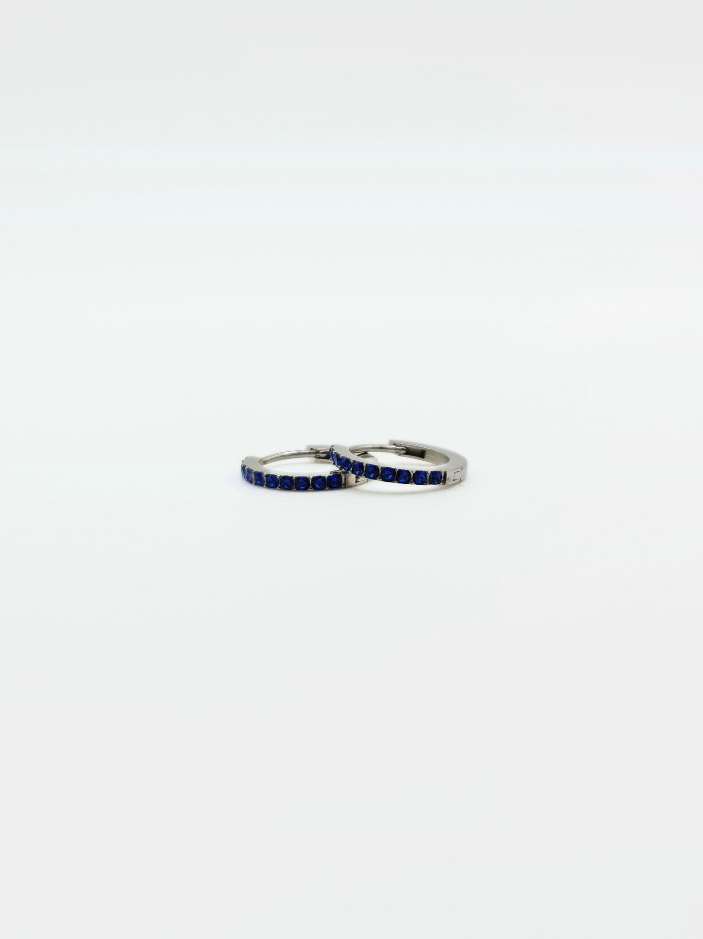 The Maija 'September' Sapphire Birthstone Silver Finish Tarnish Free Crystal Huggie Hoop Earrings.