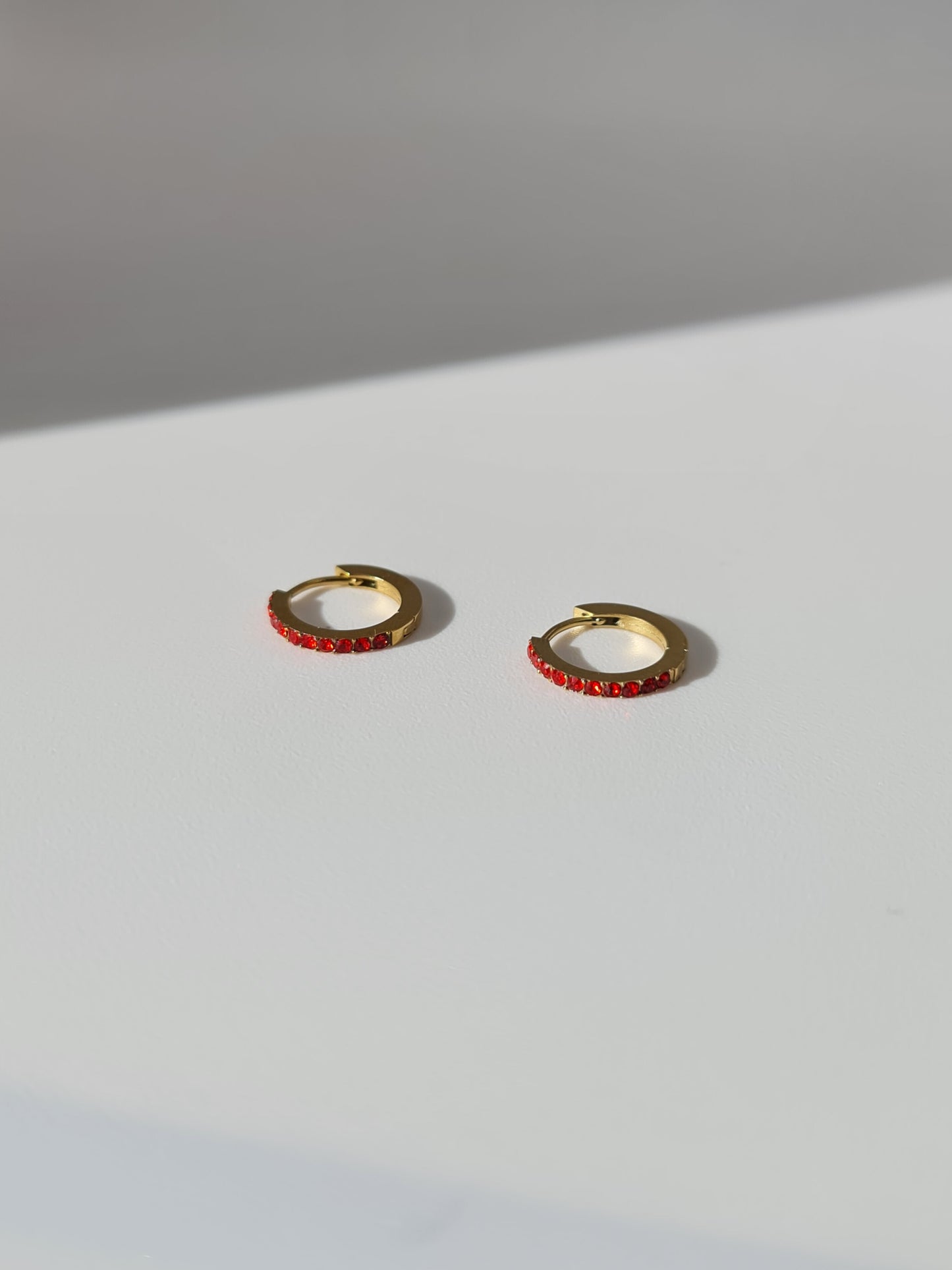 The Maija 'January' Garnet Birthstone 18k Gold Plated Stainless Steel Crystal Huggie Hoop Earrings.
