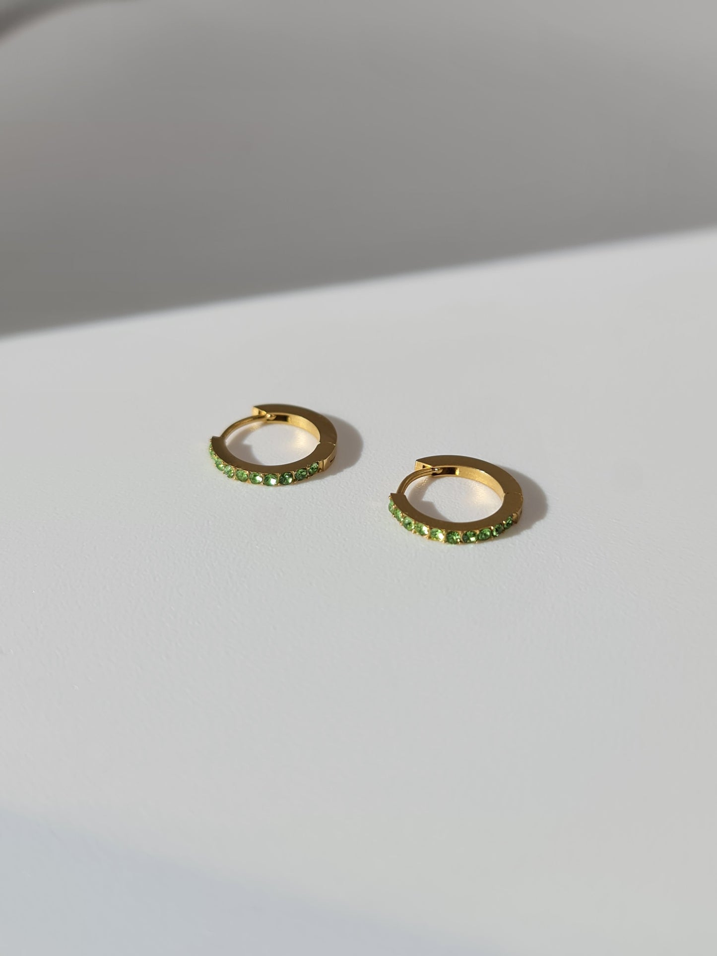 The Maija 'August' Peridot Birthstone 18k Gold Plated Stainless Steel Crystal Huggie Hoop Earrings.