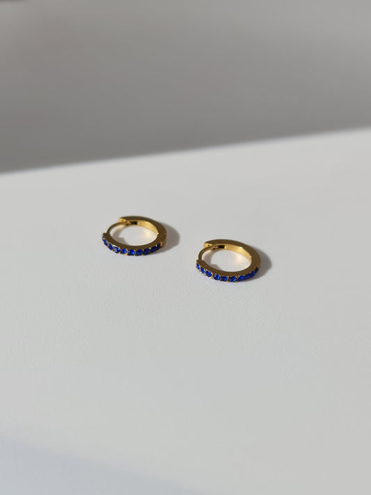 The Maija 'September' Sapphire Birthstone 18k Gold Plated Stainless Steel Crystal Huggie Hoop Earrings.
