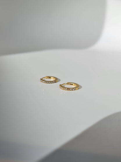 The Maija 'April' Diamond CZ Birthstone 18k Gold Plated Stainless Steel Crystal Huggie Hoop Earrings.