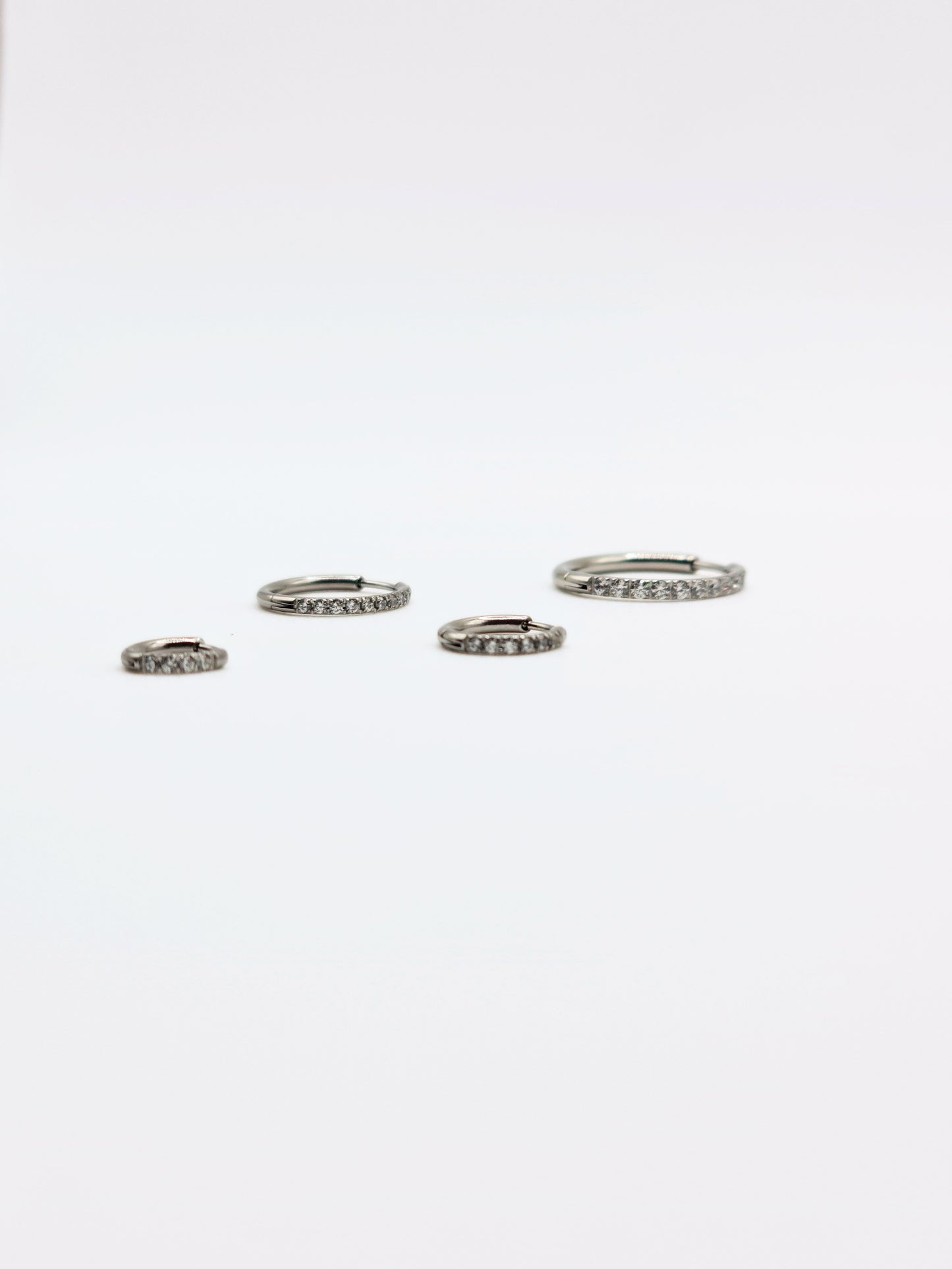 The Alaia Essentials Silver Finish Tarnish-Free Crystal Pave Huggie Hoop Earrings in 16mm