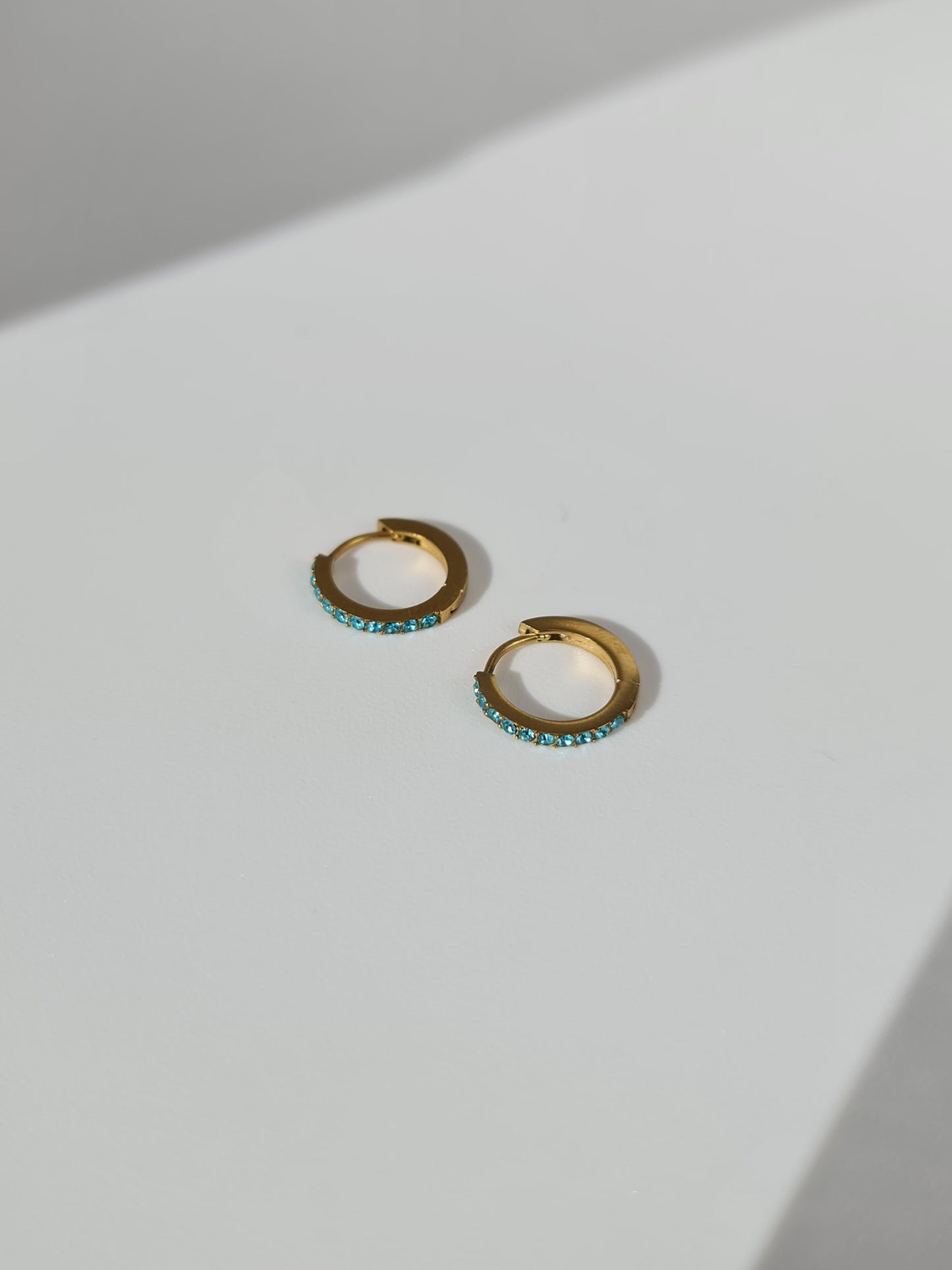 The Maija 'December' Turquoise Birthstone 18k Gold Plated Stainless Steel Crystal Huggie Hoop Earrings.