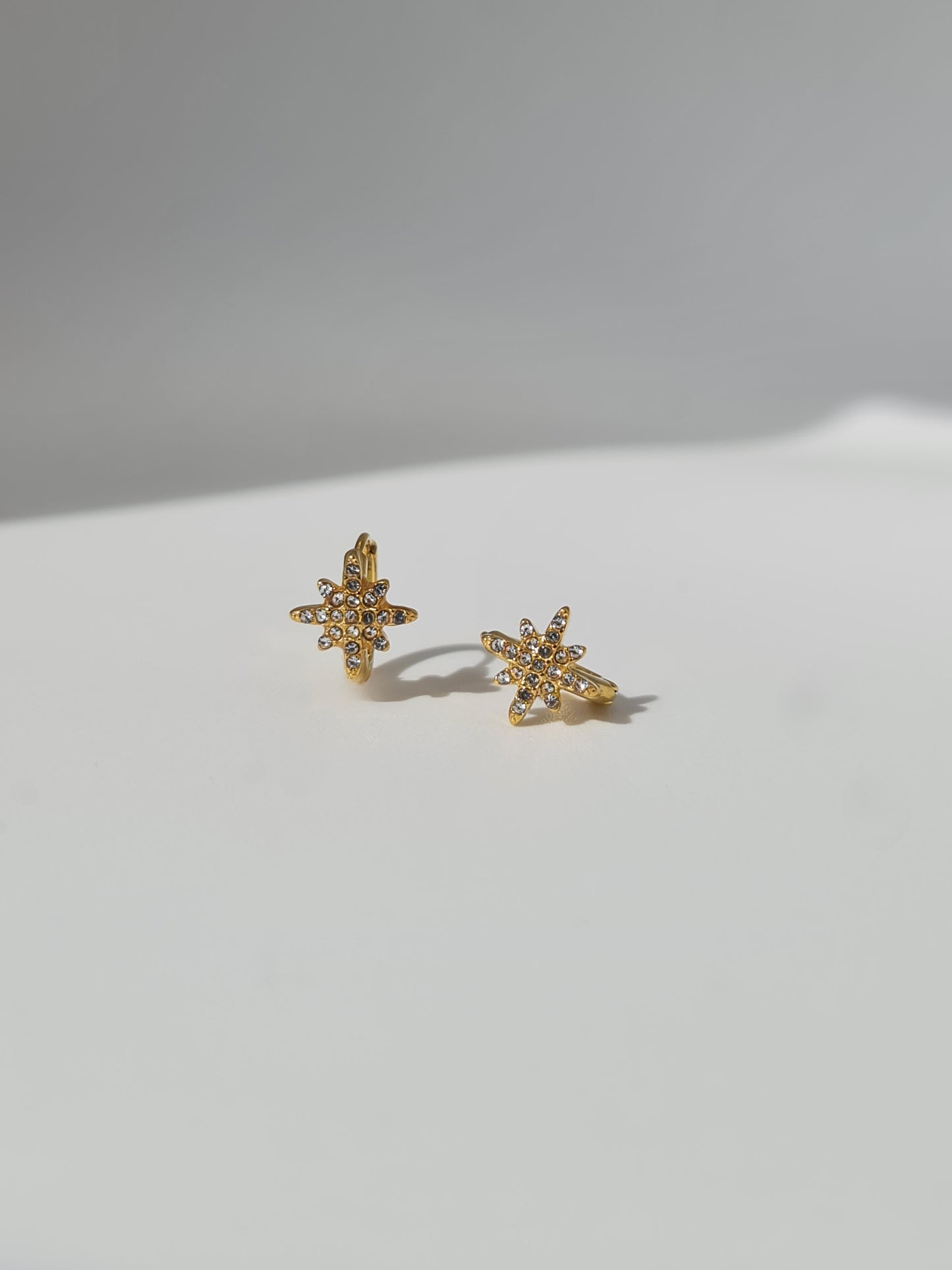 The Astra 18k Gold Plated Stainless Steel Cubic Zirconia Pave Crystal Celestial Star Huggie Hoop Earrings.