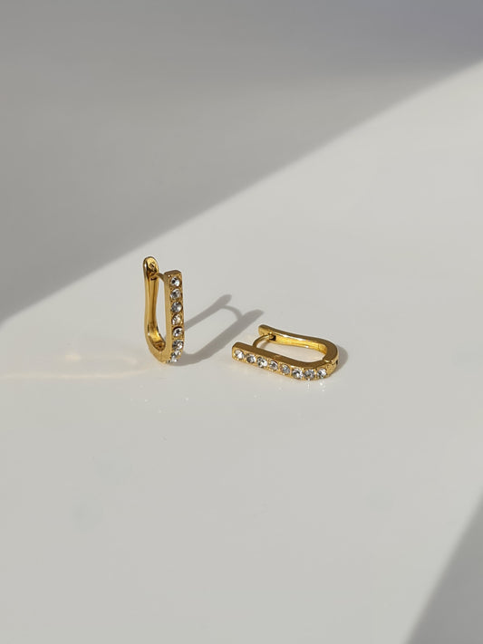 The Bobbie 18k Gold Plated Stainless Steel Cubic Zirconia Pave Crystal Oval Huggie Hoop Earrings.